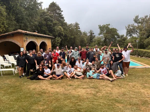 A large group of Tangelo Games employees photographed in the garden